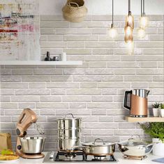 a white brick wall in a kitchen with pots and pans on the stove top