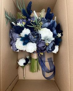 a bouquet of blue and white flowers in a box