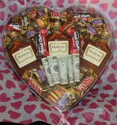 a heart shaped box filled with liquor bottles and candy bar wrappers in the shape of a heart