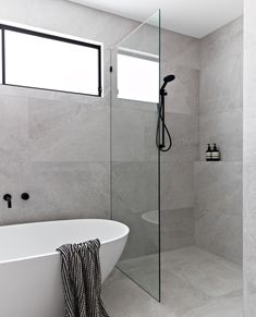 a white bath tub sitting next to a walk in shower