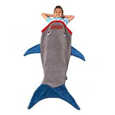 a young boy laying on top of a shark pillow