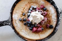 a pancake topped with berries and whipped cream