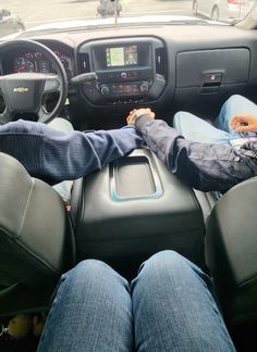 a person is sitting in the driver's seat of a truck with their feet on the steering wheel