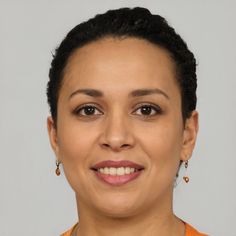 a woman in an orange shirt is smiling at the camera and she has her eyes closed