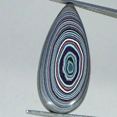 a close up of a metal object on a white surface with lines in the middle