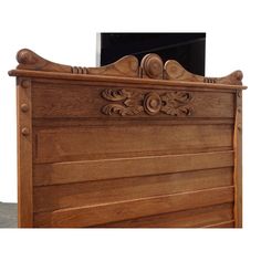 a wooden bed frame with carvings on it