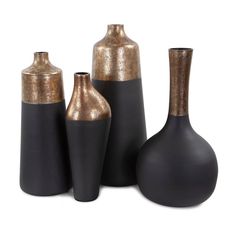 three black and gold vases sitting next to each other