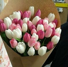 a bouquet of pink and white tulips on a table