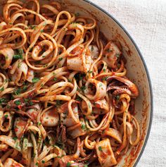 a skillet filled with pasta and shrimp