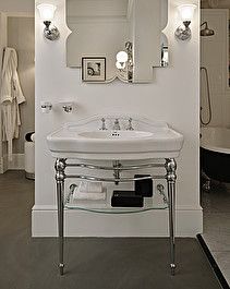 a white sink sitting under a mirror in a bathroom next to a black bath tub