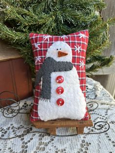 a snowman pillow sitting on top of a wooden sled