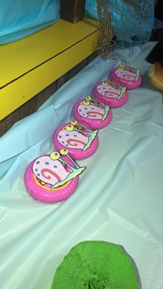 a table topped with pink and green birthday cakes