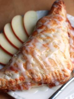 some food is on a white plate with silverware next to it and sliced apples