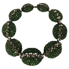 Extraordinary Balenciaga Bunny Mellon Haute Couture choker necklace. Composed of graduated eliptical domes of japanned bronze metal with hand prong set graduated olivine emerald Swarovski paste stones with and large grey crystals running down the center. Fabricated by Roger Scemama. Provenance Bunny Mellon. Tiny Size. Unsigned. Excellent Condition Length 15.75", x Width 1 7/8" Central oval motif. Balenciaga Haute Couture, Bunny Mellon, Vintage Balenciaga, Wallis Simpson, Couture Necklace, Vintage Choker Necklace, Cristóbal Balenciaga, Vintage Choker, Bronze Metal