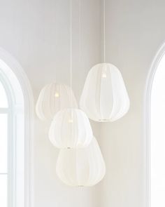 three white lamps hanging from the ceiling in a room