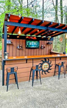 an outdoor bar with stools and lights