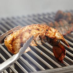 there is a piece of meat on the grill with tongs next to it,