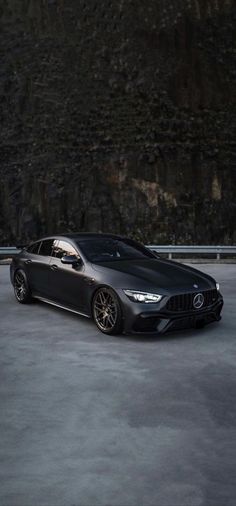 a black sports car parked in front of a mountain