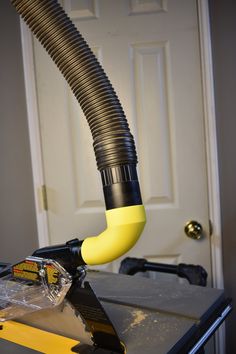 a yellow and black blow dryer sitting on top of a table next to a door