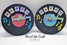 two black records with happy birthday and musical notes on them are sitting side by side