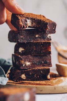 a stack of brownies sitting on top of a wooden cutting board