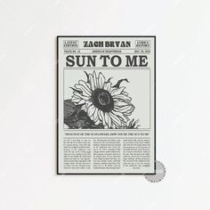 the sun to me newspaper is displayed on a white wall with a black and white photo