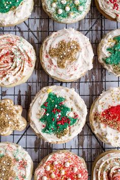 decorated cookies on a cooling rack with frosting and sprinkles