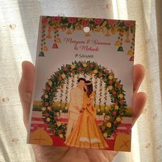 a person holding up a card with an image of a bride and groom