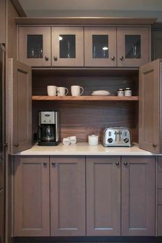 a kitchen with wooden cabinets and white counter tops, along with a coffee maker on the left