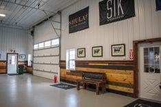 the inside of a building with several pictures on the wall and a bench in front of it