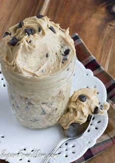 a glass jar filled with frosting and chocolate chips on top of a white plate