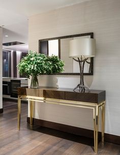 a table with a plant on it in front of a mirror and lampshade