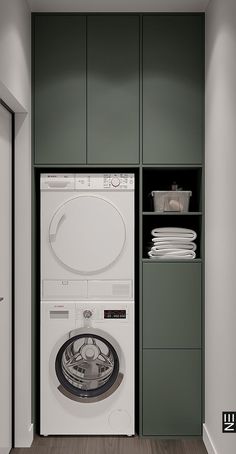 a washer and dryer in a room with green cupboards on the wall