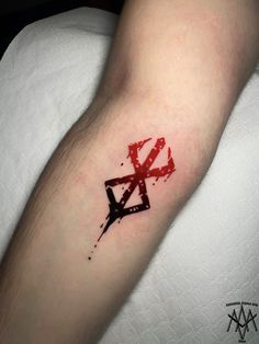 a person with a tattoo on their arm that has the letter k in red ink