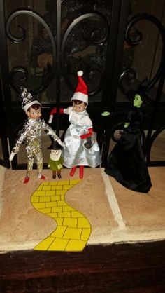 two elfs are standing on the steps in front of a gate with a yellow path painted on it