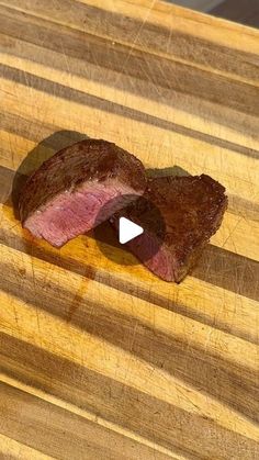 a piece of meat sitting on top of a wooden cutting board