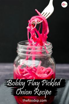 a fork sticking out of a mason jar filled with red onion rings and shredded onions