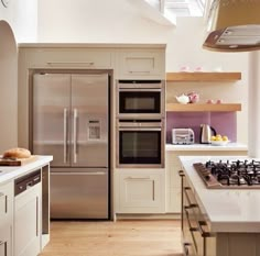 a modern kitchen with stainless steel appliances and wood flooring