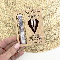 a person holding up a wooden card with an image of a suit and tie on it