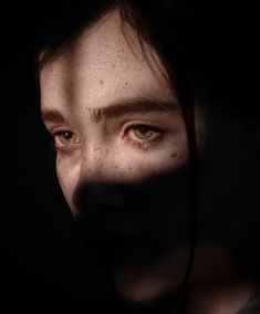 a woman with freckled hair and green eyes is seen through the shadow of her face