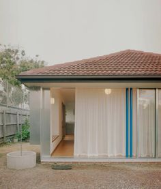 a small house with an open door and white curtains