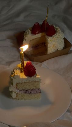 a slice of cake on a plate with a candle in the middle and strawberries on top