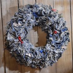 a wreath made out of old jeans hanging on a wooden wall