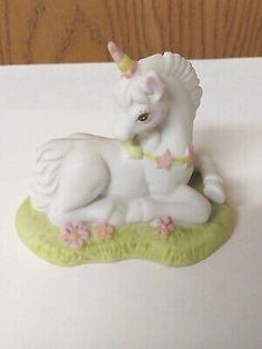 a white unicorn figurine sitting on top of a table