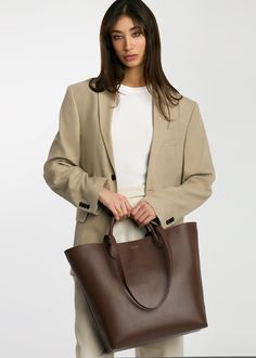 It’s time for a bag designed just for you. Every detail—from the quality of vegetable-tanned leather to the interior pockets to the silhouette—the Mila Tote was designed with the working professional in mind. Take her from the office with enough space for your 13" laptop, planner, and other everyday essentials to an after-work shopping date. By tethering the sides, you basically have two designs in one. Just like you, the Mila Tote is for the boss woman who can do it all! Professional Leather Satchel For Everyday Use, Sleek Shoulder Bag For Work, Sleek Satchel Bag For Work, Professional Leather Shoulder Bag For Everyday Use, Sleek Tote Bag For Workwear, Sleek Satchel For Workwear, Sleek Tote Bag For Work, Large Capacity Double Handle Laptop Bag For Work, Sleek Workwear Bag