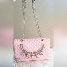 *****Rare Find***** This Gorgeous Quilted Guess Purse Is The Perfect Gift For Any Guess Collector. One Of A Kind And Beautifully Crafted. This Is A Vintage And Retired Bag. Features: Silver Metal Chain Straps With Pink Handles, Guess Pink And Silver Charm Letters On A Thick Silver Link Chain, Easy Snap Closure, Canvas Guess Logo Material Inside, One Zipper And 3 Open Pockets Inside, A Canvas Logo Divider, 1 Zipper Pocket Outside, And Four Silver Metal Feet On The Base Of The Bag. Measurements: 10.5" W X 7.5" H From The Top Of The Strap To The Bottom Of The Bag 21" Mint Condition! Smoke Free & Clean Home Fast Shipper 5 Star Seller Posh Ambassador 11 Pa Pink Handles, Guess Purse, Quilted Purse, Guess Purses, Guess Logo, Silver Link Chain, Quilted Purses, Bag Measurements, Guess Bags