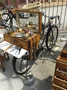 an old fashioned bicycle is parked in front of a fence with other antique items on it