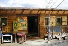 a small wooden building sitting on the side of a road