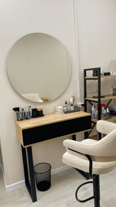 a white chair sitting in front of a mirror on top of a wooden desk next to a stool