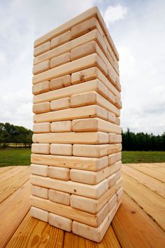 a stack of wooden blocks sitting on top of a wooden floor next to a field